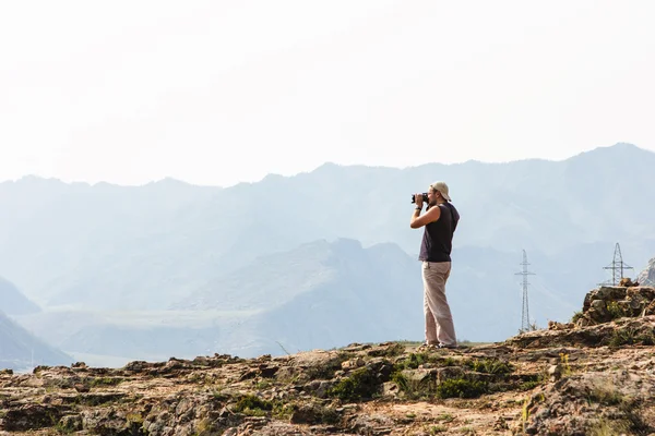 Fotógrafo de naturaleza con cámara digital en la cima de la montaña —  Fotos de Stock