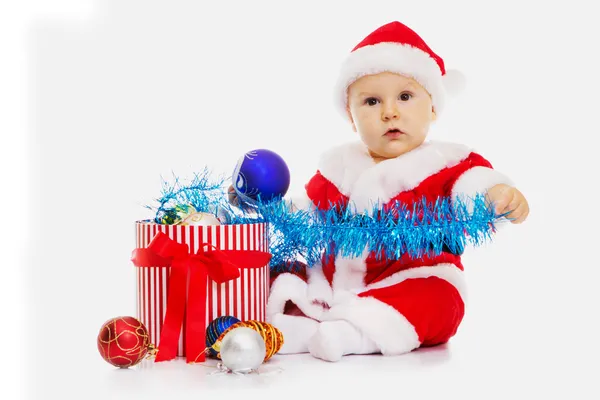 O menino em uma imagem de Papai Noel senta-se — Fotografia de Stock