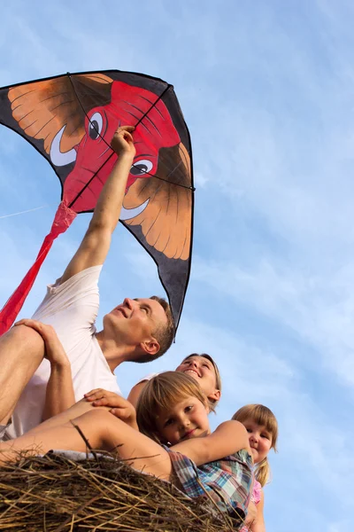 Family from four against the blue sky flying kite. — Stock Photo, Image