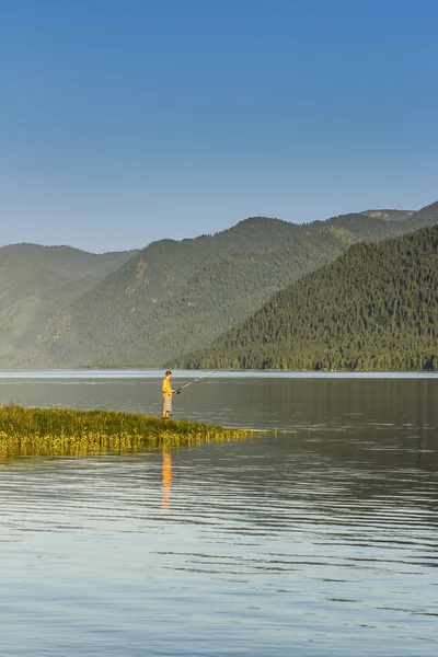 One fisherman on the bank of reservoir in mountains — Stock Photo, Image