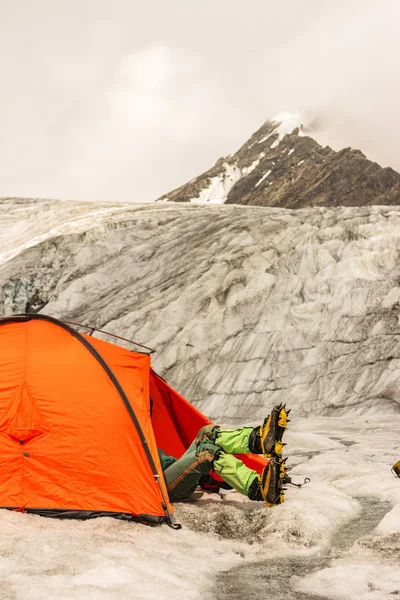 De klimmer heeft een rust liggen in de tent op gletsjer — Stockfoto