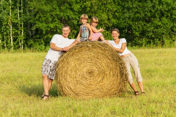 Familjen utomhus har resten på hö — Stockfoto