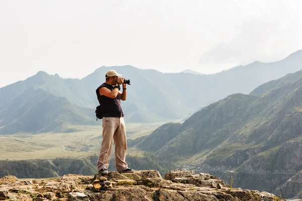 Fotógrafo profissional na montanha faz tiroteio — Fotografia de Stock