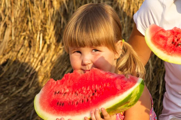 Girl eats red tasty water-melon — Stock Photo, Image