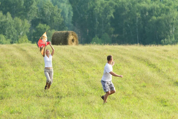 Jovem corrida no prado voando pipa . — Fotografia de Stock