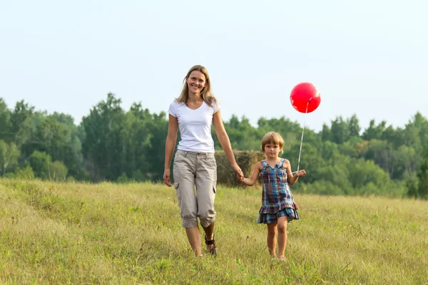 Mutter und Tochter gehen mit Ball in der Hand voran — Stockfoto