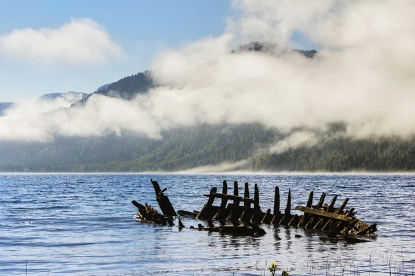 Wreck of old wooden ship on the Lake Teletsky in mountains. — Stock Photo, Image