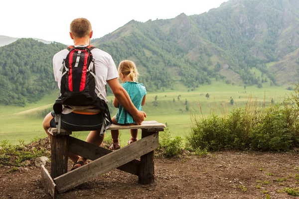 Fadern med dotter i famn sitta på bänken — Stockfoto