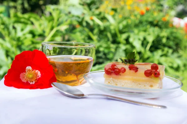白い布の上おいしい紅茶ケーキとポピーの花 — ストック写真