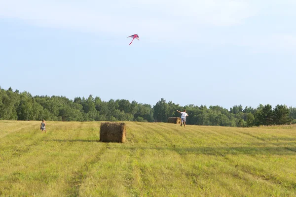 Vater und Tochter rennen über das Feld. — Stockfoto