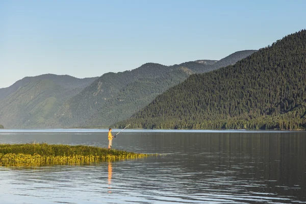 O pescador no dia de verão na margem do lago — Fotografia de Stock