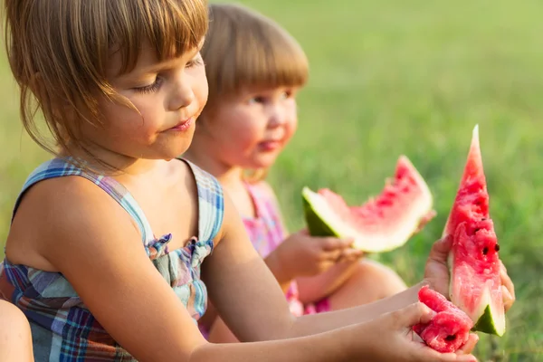 Flickor äter söta och välsmakande vatten-melon — Stockfoto