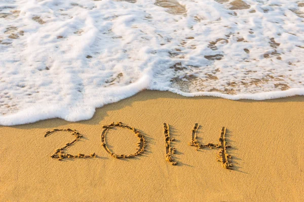 New Year 2014 is coming concept. Inscription 2014 on beach sand. Stock Photo