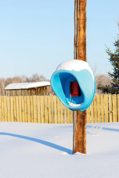 Lonely phone among snow glade — Stock Photo, Image