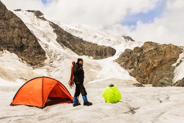 The climber costs on glacier near tent — Stock Photo, Image