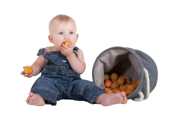 Kleine jongen een abrikoos eten — Stockfoto