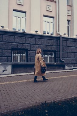 Bir kadın işe gider, paltolu bir kadın, sokak tarzı. Şehirde dolaşıyorum.