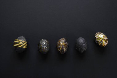 Siyah arkaplanda altın desenli siyah paskalya yumurtaları