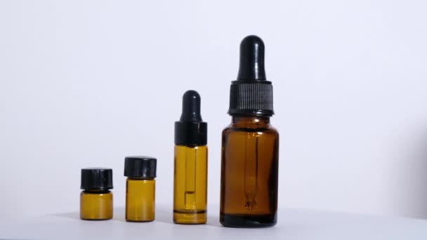 Various empty bottles of essential oils on a white background. — Stock Video