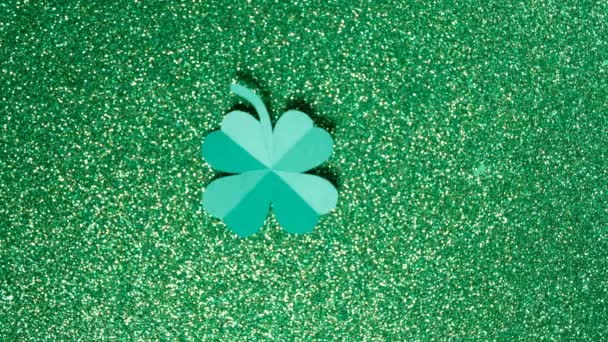 圣帕特里克节 一片从纸上剪下来的三叶草在闪亮的绿色背景上旋转着 高质量的4K镜头 — 图库视频影像