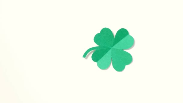 A leaf of clover cut out of paper is spinning on a white background. — Stock Video