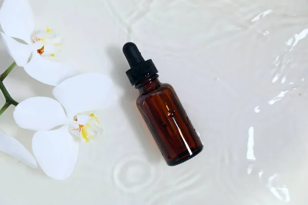 Пляшка ефірної олії з білою орхідеєю — стокове фото