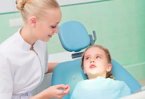 Joven médico mujer y niña en el consultorio del dentista — Foto de Stock