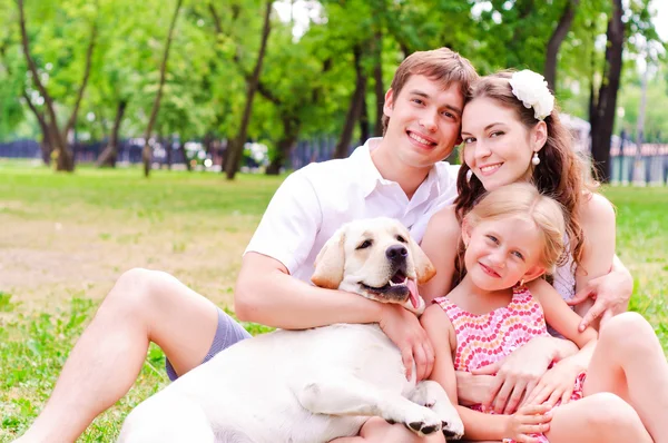Glad ung familj med labrador — Stockfoto