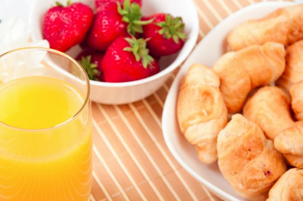 Frukost med bär, apelsinjuice och croissant — Stockfoto