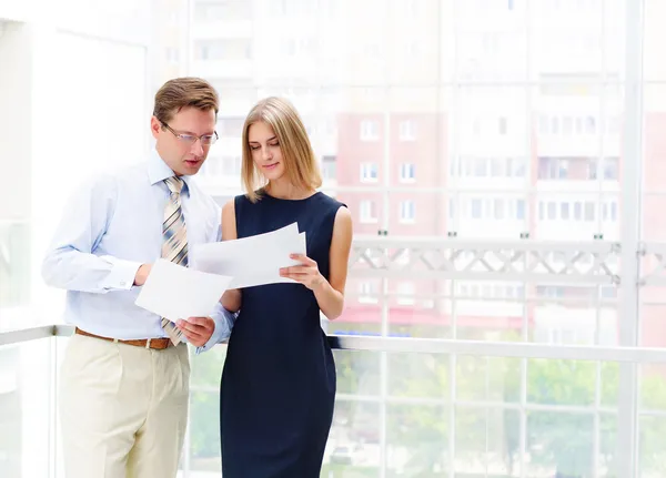 Affärsman och affärskvinna på kontoret för att diskutera rapporter — Stockfoto