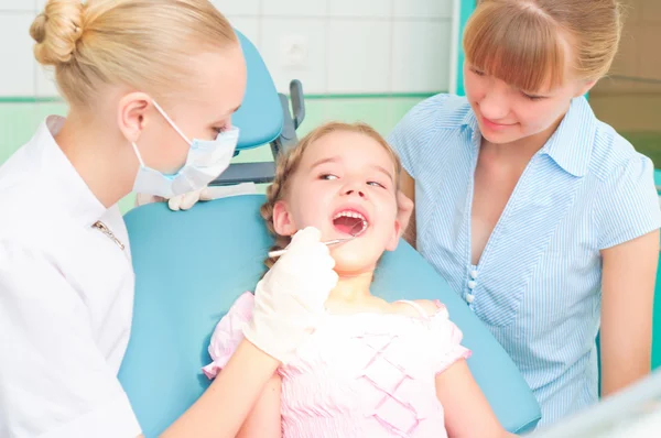 Vrouwelijke tandartsen onderzoekt een kind — Stockfoto