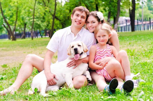 Jovem família feliz com Labrador — Fotografia de Stock