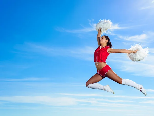 Jovem cheerleader em vermelho traje saltando — Fotografia de Stock