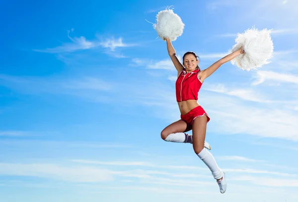 Jonge cheerleader in rood kostuum springen — Stockfoto