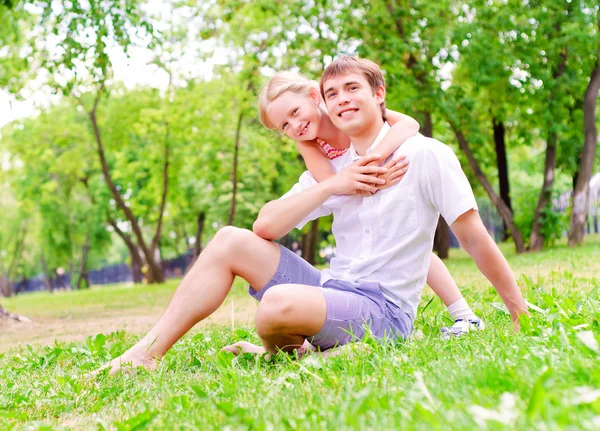 Père et fille assis ensemble sur l'herbe — Photo