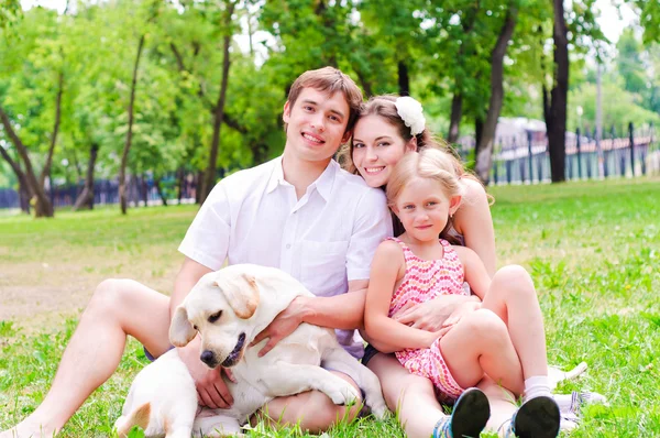 Jovem família feliz com Labrador — Fotografia de Stock