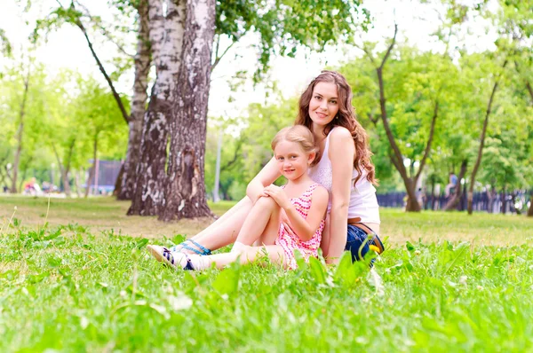Moeder en dochter samen zitten op het gras — Stockfoto