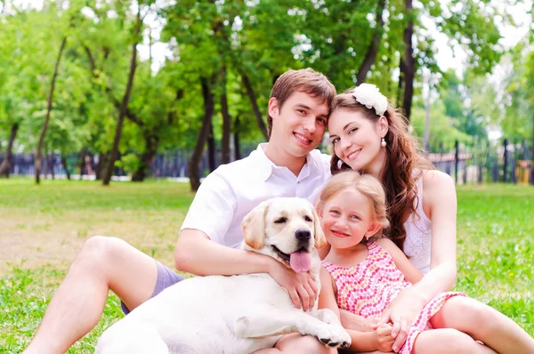 Glad ung familj med labrador — Stockfoto