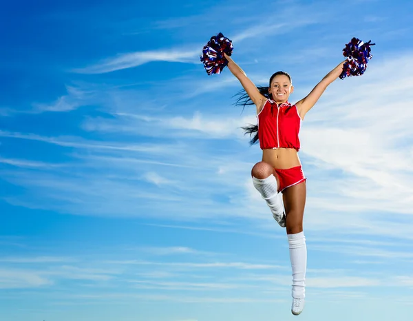 Jonge cheerleader in rood kostuum springen — Stockfoto