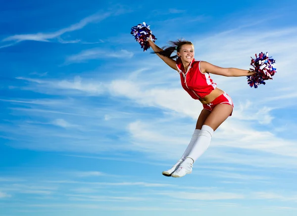 Junge Cheerleader im roten Kostümspringen — Stockfoto