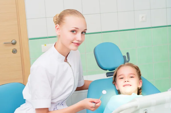 Joven médico mujer y niña en el consultorio del dentista —  Fotos de Stock