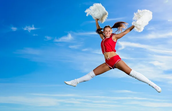 Jeune pom-pom girl en costume rouge saut — Photo