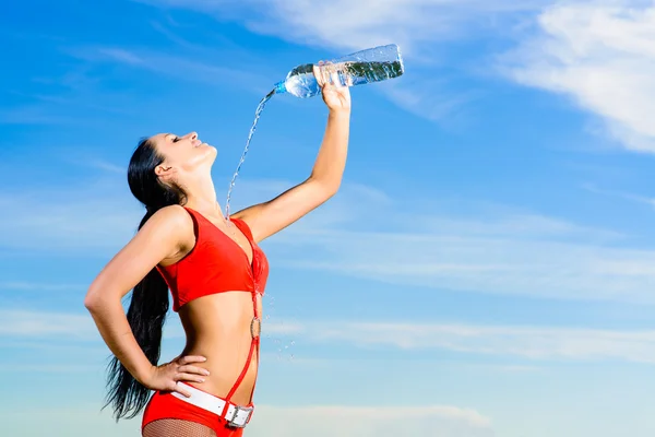 Sport dziewczynka w czerwonym mundurze butelkę wody — Zdjęcie stockowe