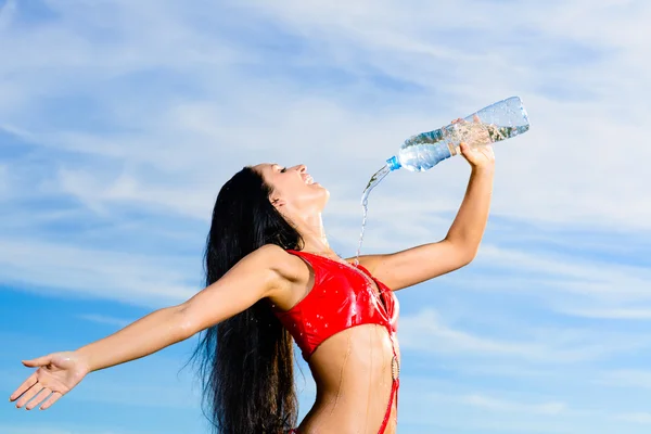 Ragazza sportiva in uniforme rossa con una bottiglia d'acqua — Foto Stock