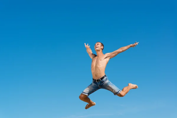 Homme sautant sur le fond bleu du ciel — Photo