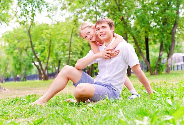 Vader en dochter samen zitten op het gras — Stockfoto