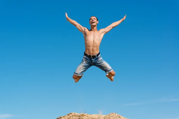 男は青い空を背景にジャンプ — ストック写真