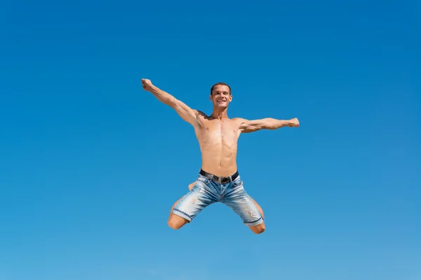 Man springen op de blauwe hemelachtergrond — Stockfoto