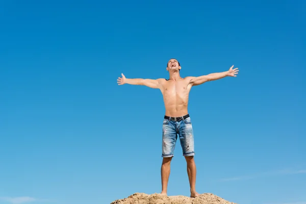 Hombre sin camisa contra el cielo azul — Foto de Stock