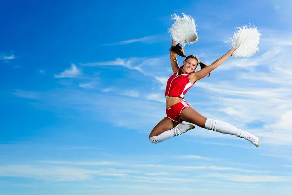 Jeune pom-pom girl en costume rouge saut — Photo